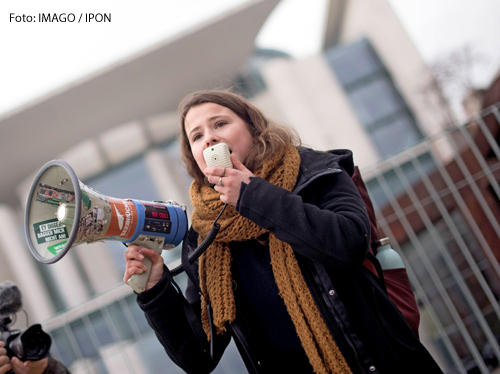 Luisa Neubauer spricht in ein Megafon bei einer Demonstration vor dem Kanzleramt in Berlin. 