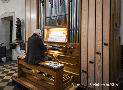 Ein Organist spielt eine Orgel. 