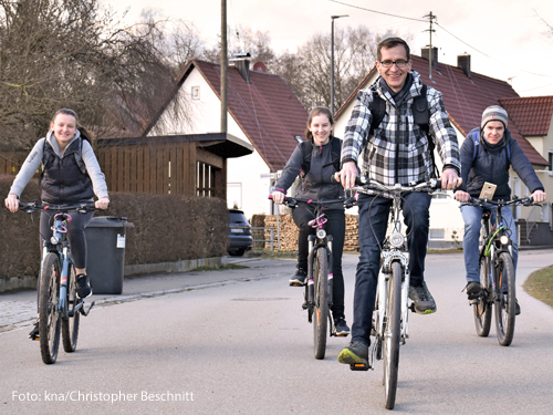 Eine Familie sitzt auf Fahrrädern. 