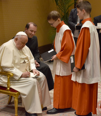 Papst Franziskus gibt den Kapellknaben Autogramme