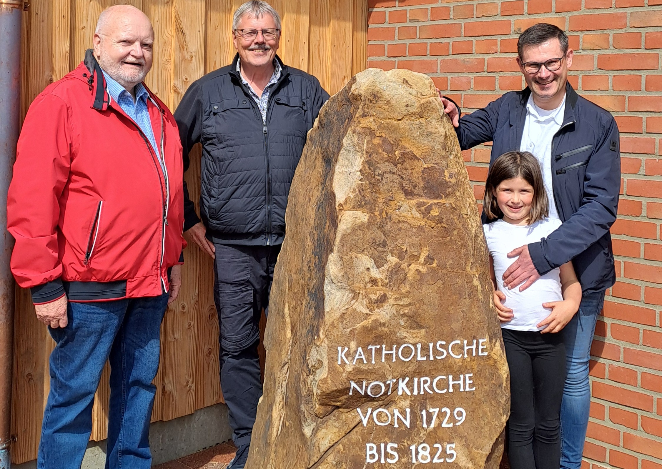 drei Männer vor einem Gedenkstein