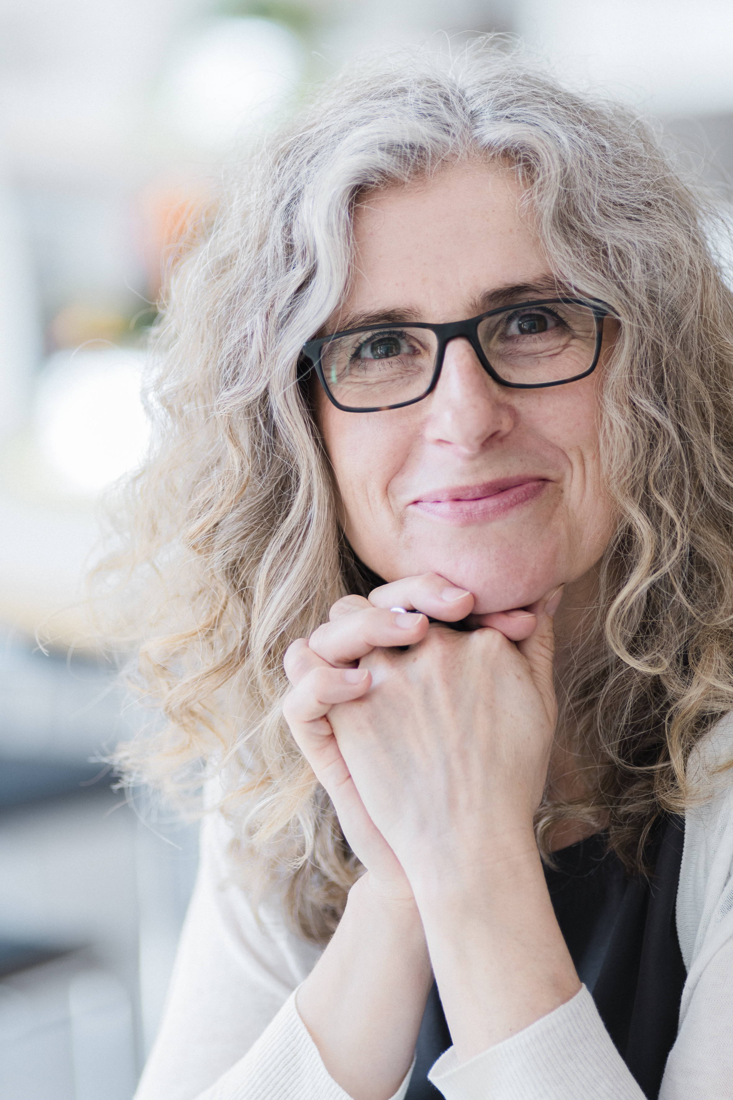 Porträtfoto von einer Frau mit grauen lockigen Haaren