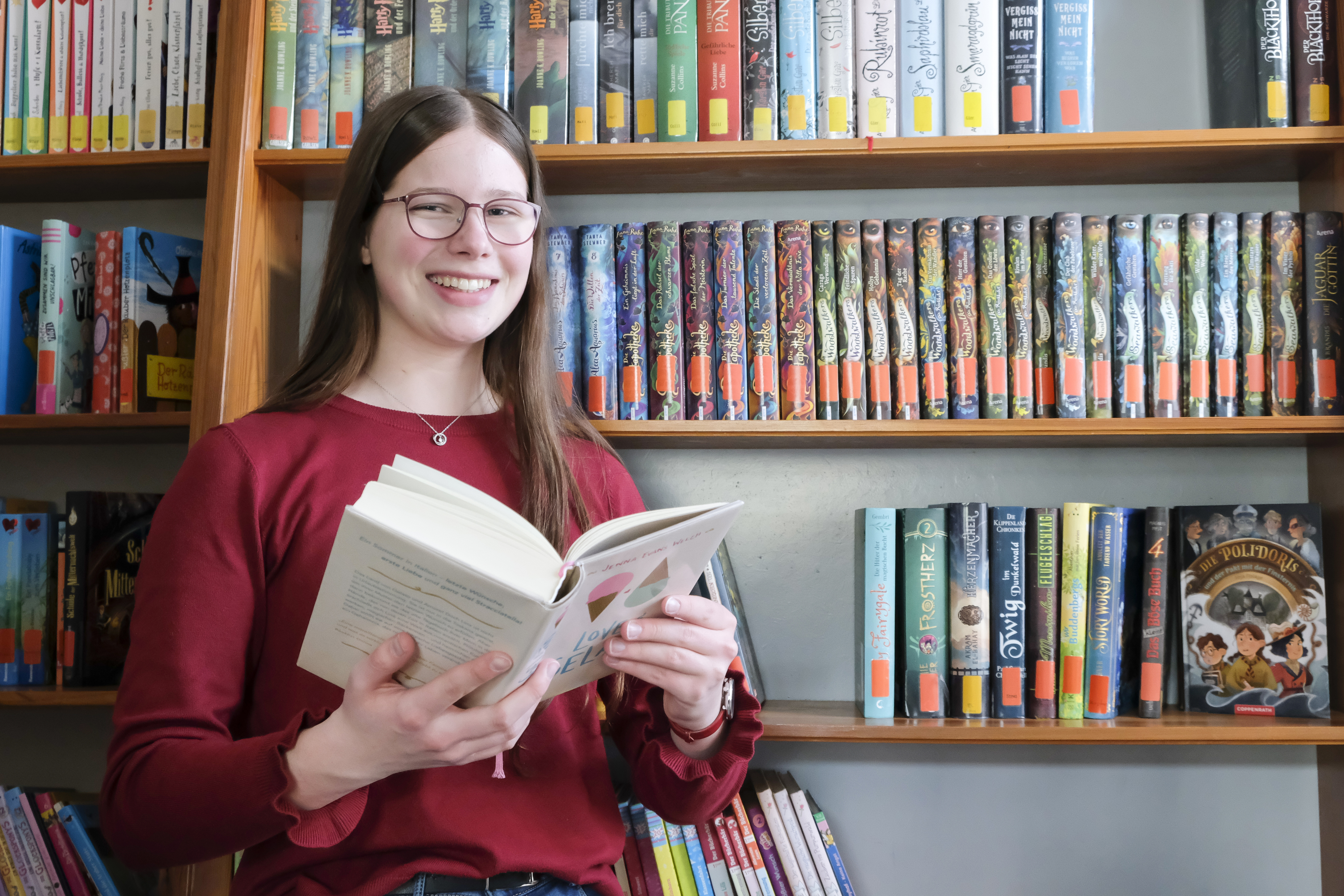 Eine junge Frau vor einer Bücherwand