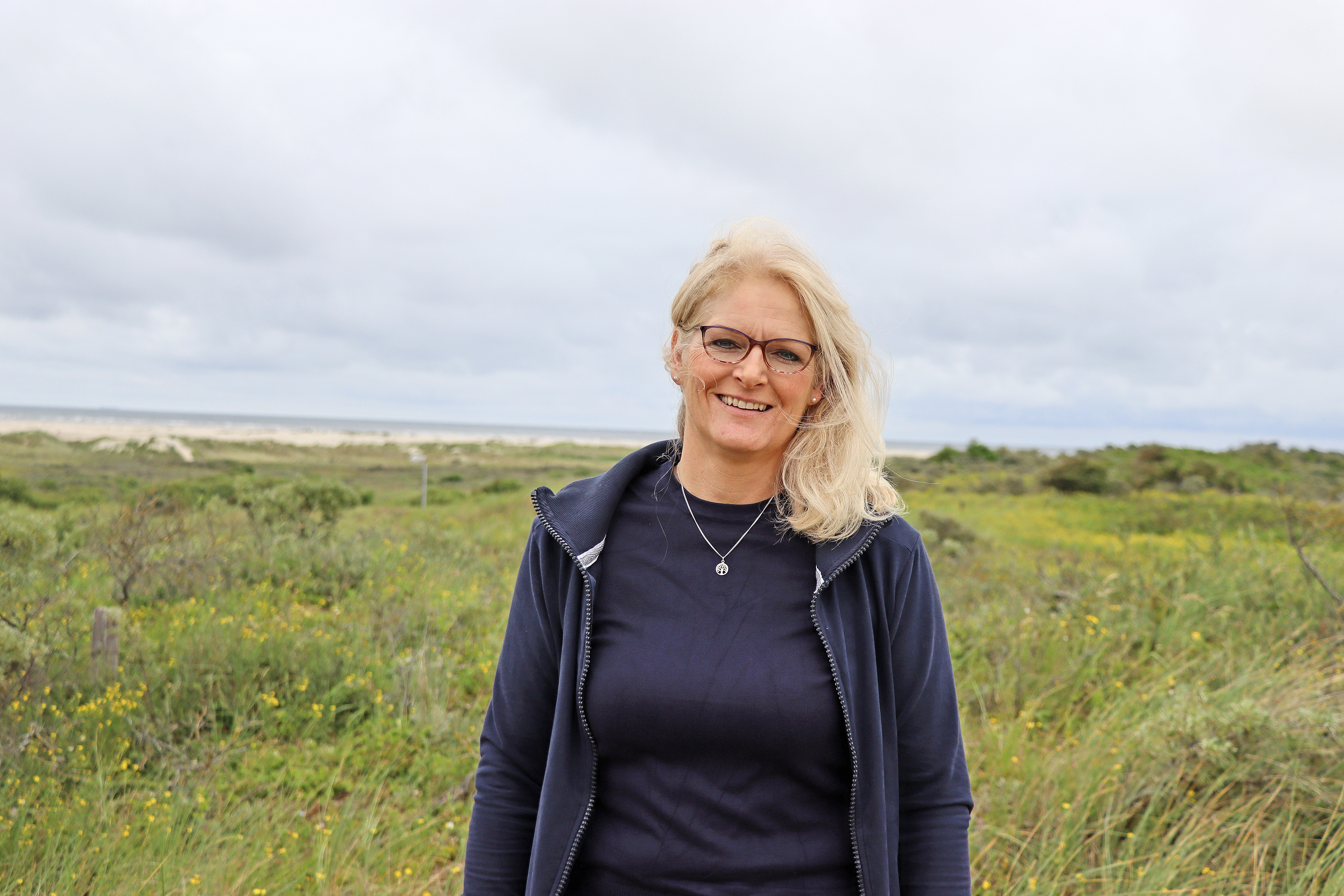 Eine Frau steht in den Dünen