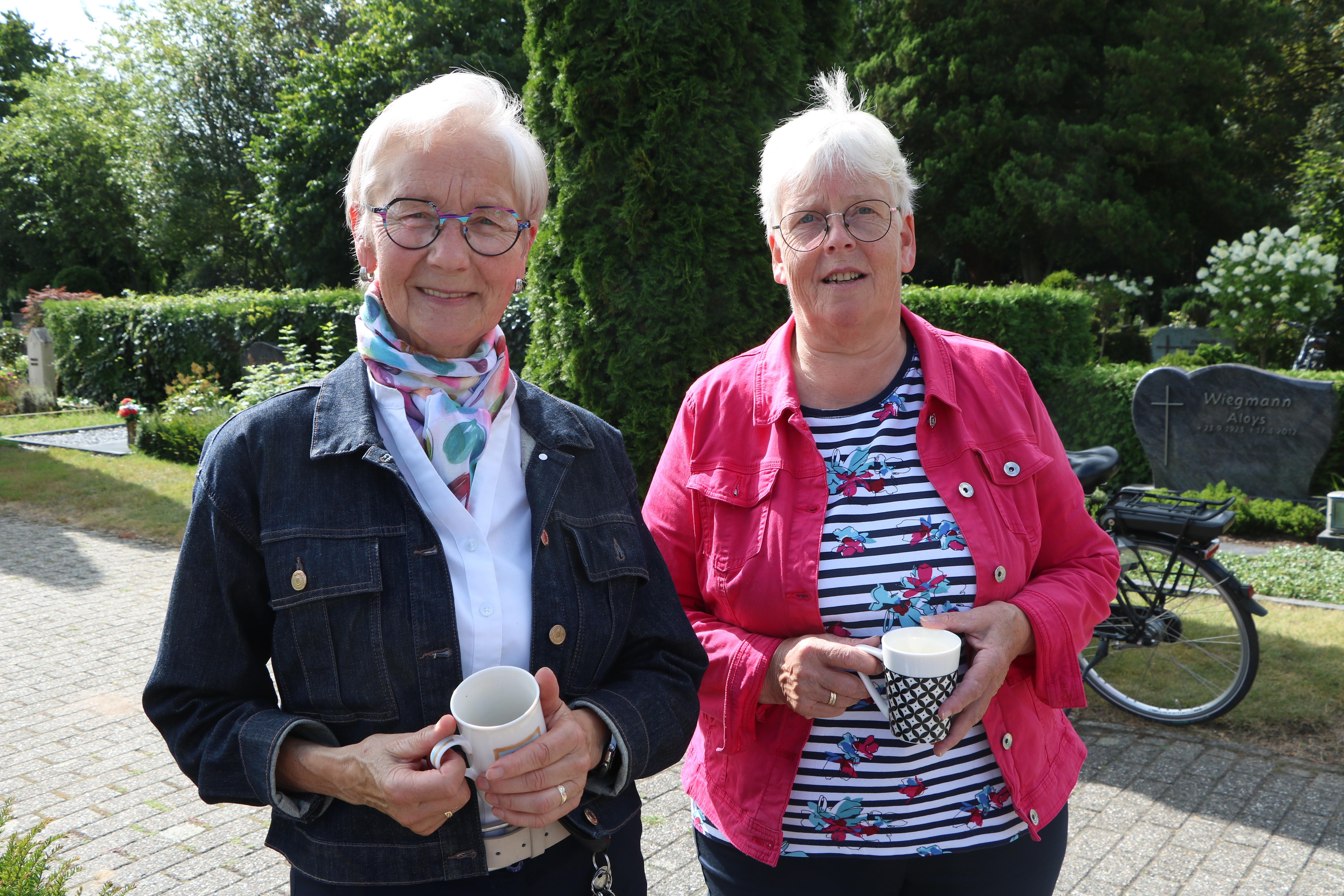 Zwei Frauen halten Kaffeetassen in der Hand.. 