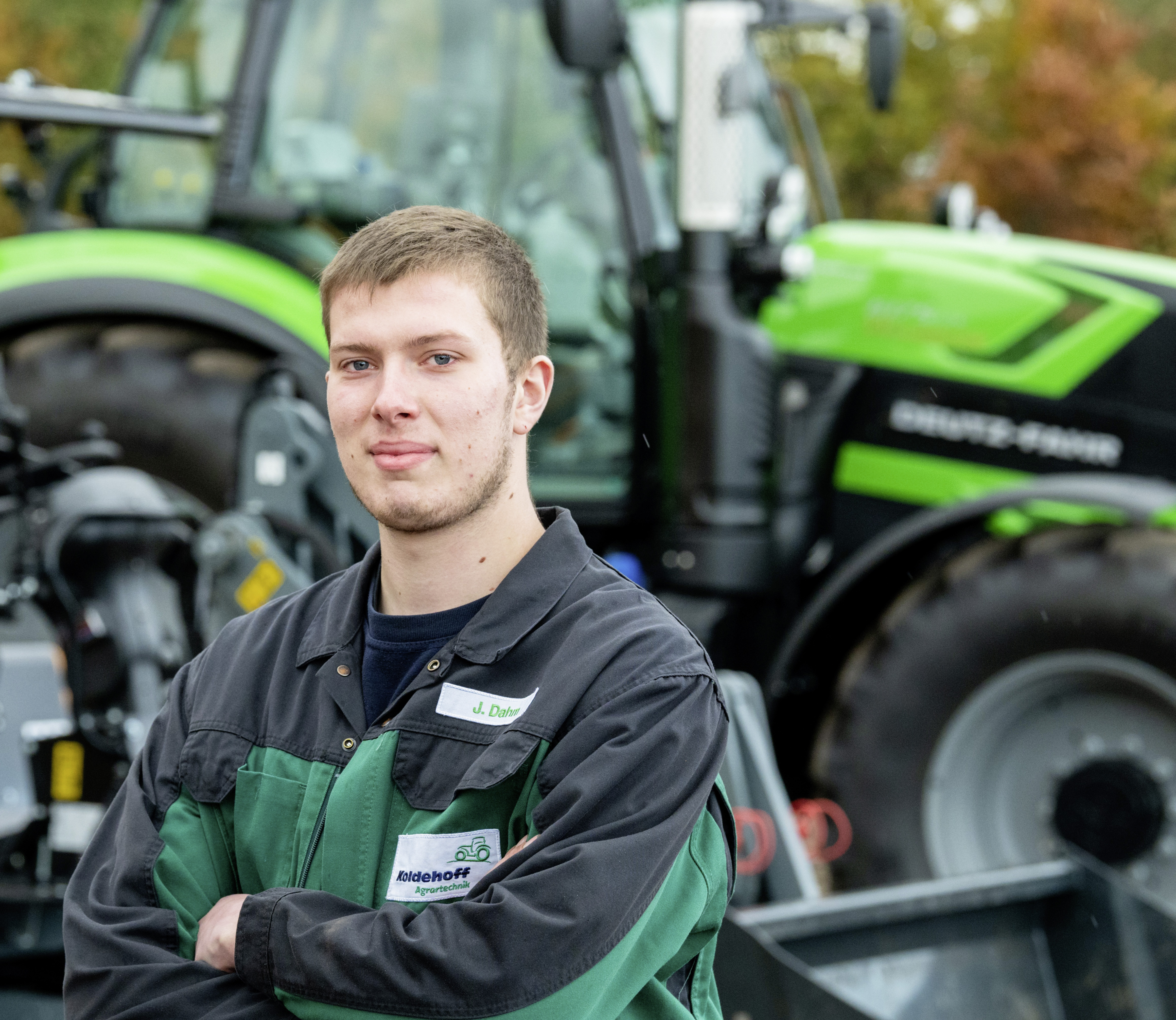 Ein junger Mann steht vor einem Trecker