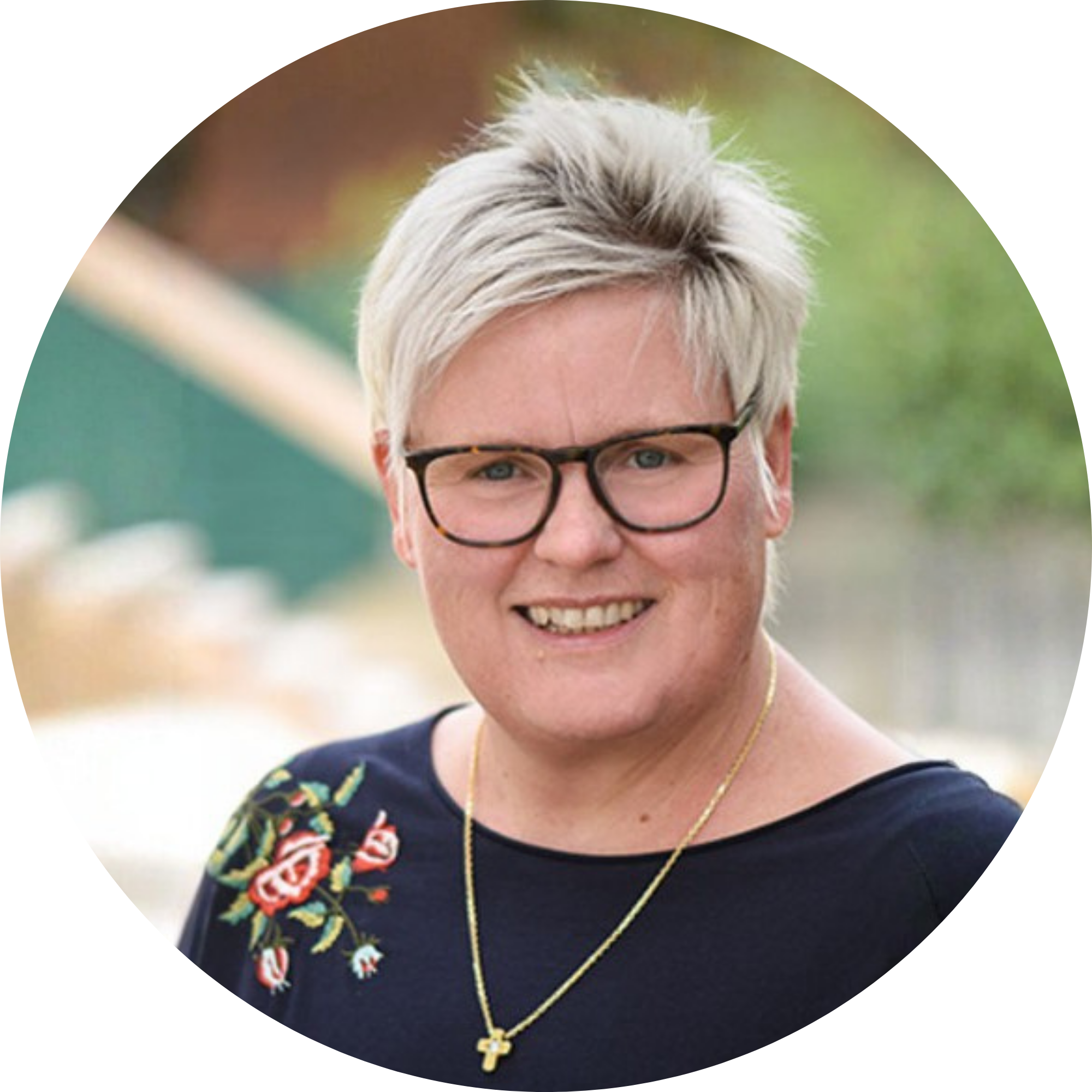 Eine Frau mit weißen, kurzen Haaren, Brille und Kreuzkette.