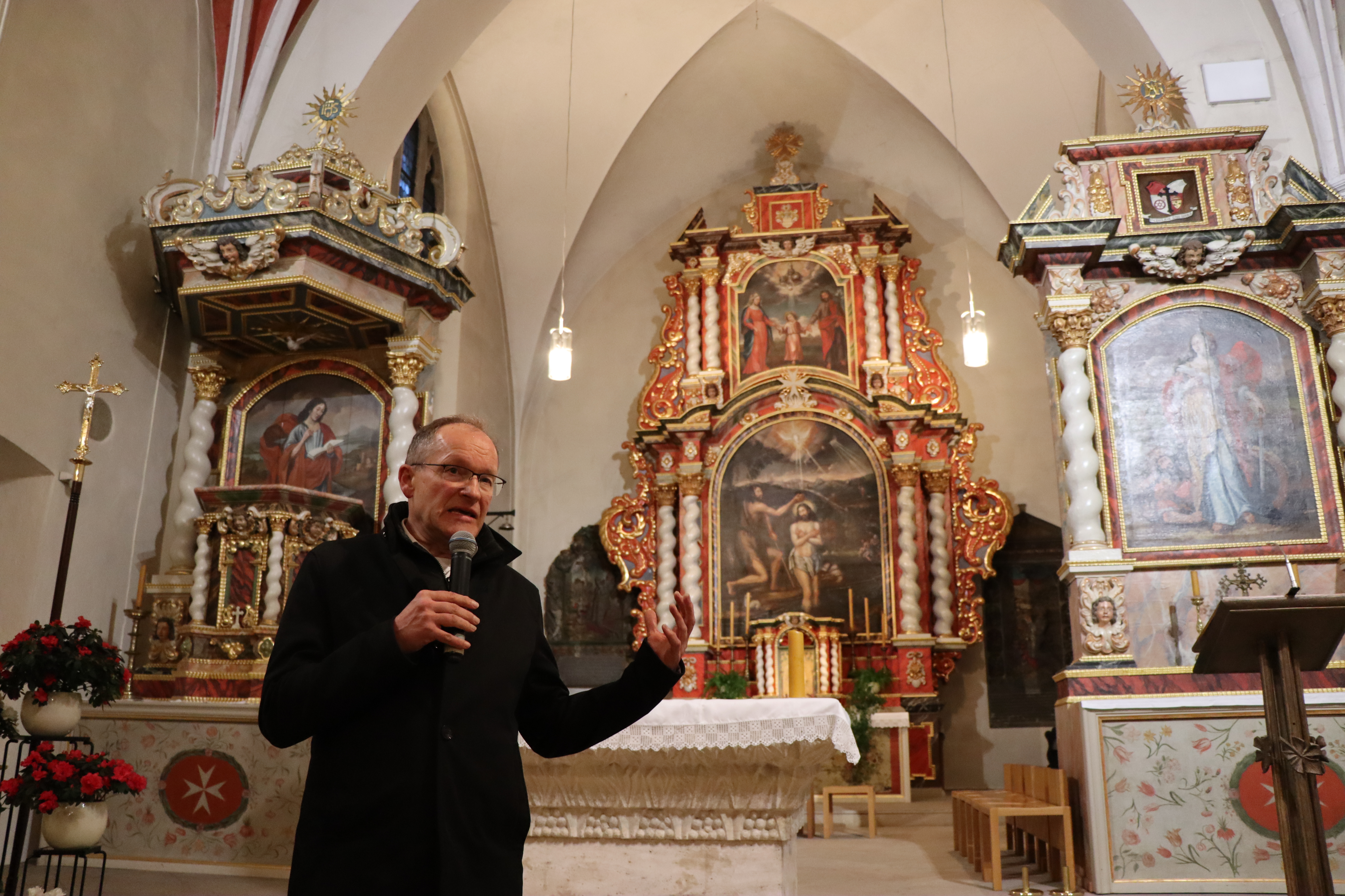 Generalvikar Ulrich Beckwermert steht in einer Kirche und hält ein Mikrofon