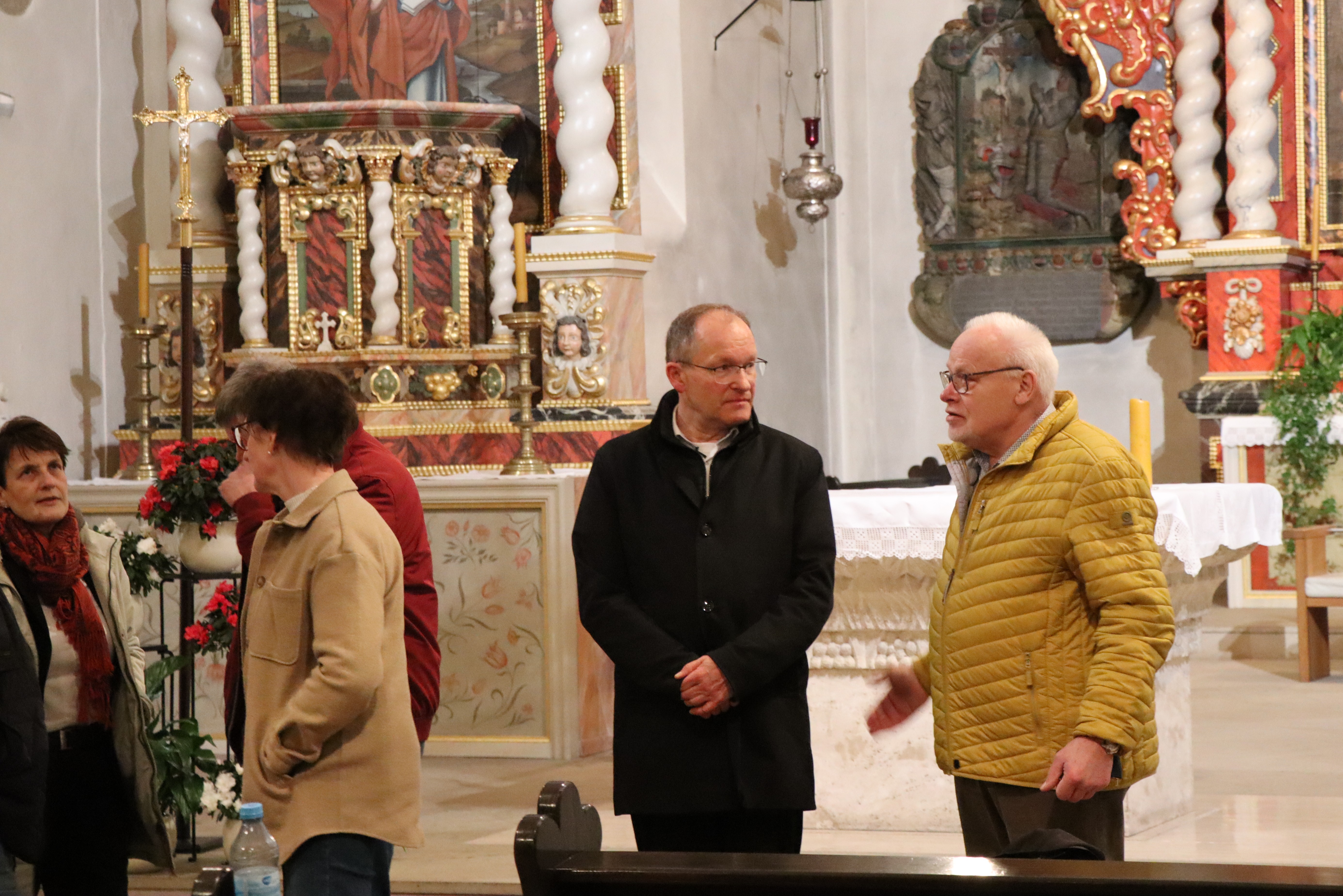 Menschen sprechen mit Finanzleiterin Astrid Kreil-Sauer und Generalvikar.