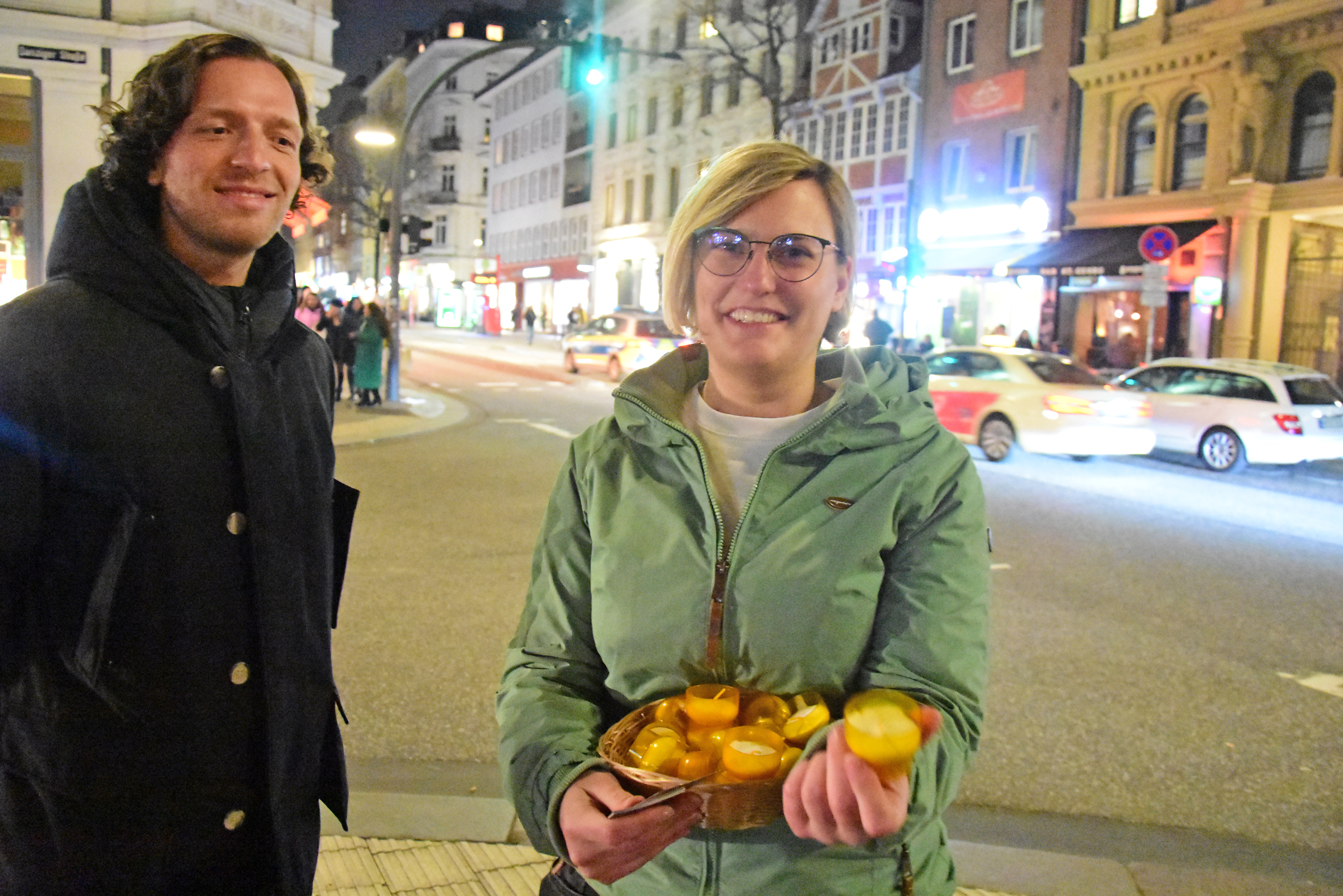 Zwei Personen mit Kerzen in einem Korb.