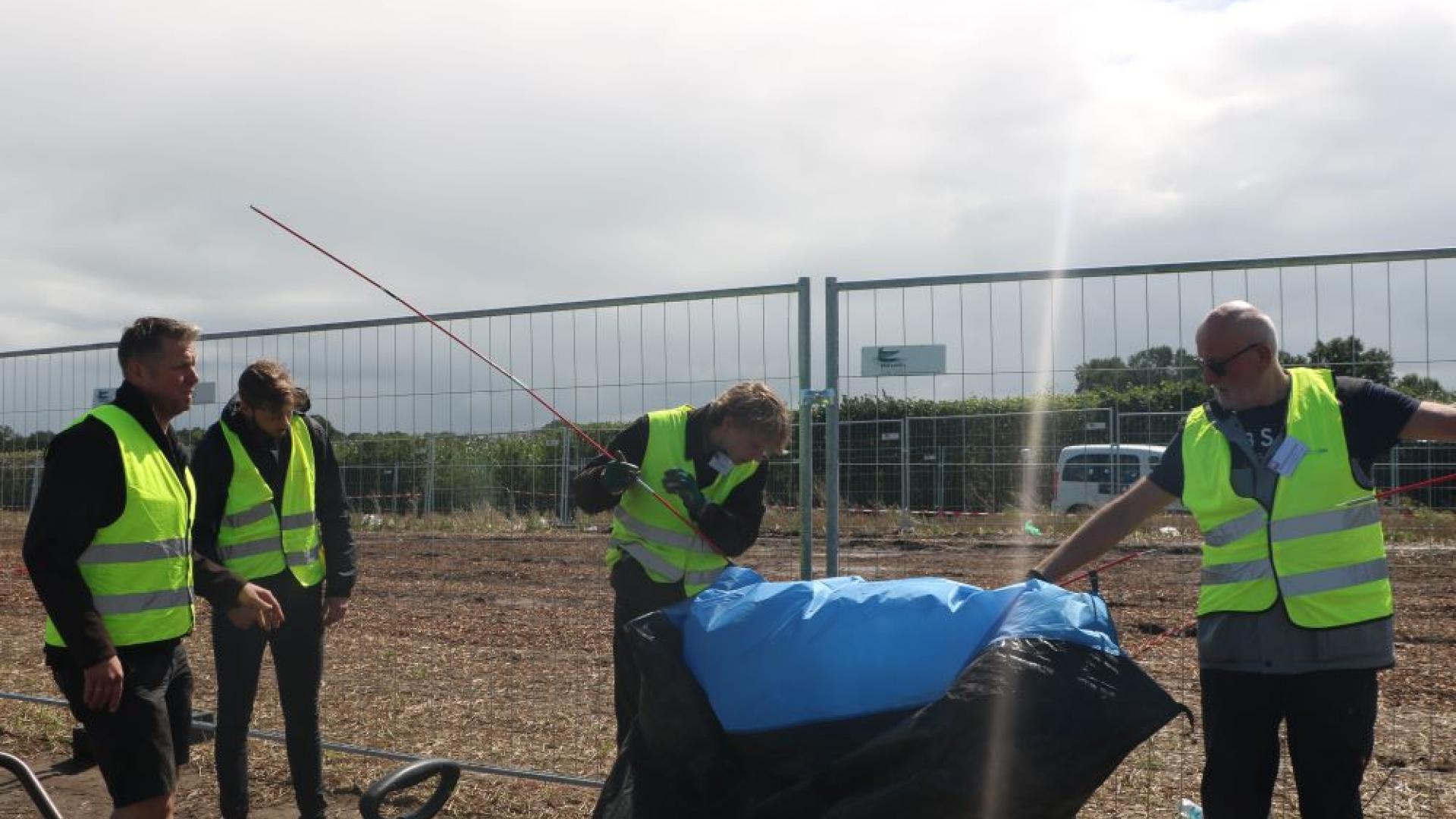 Vier Menschen bauen ein Zelt ab