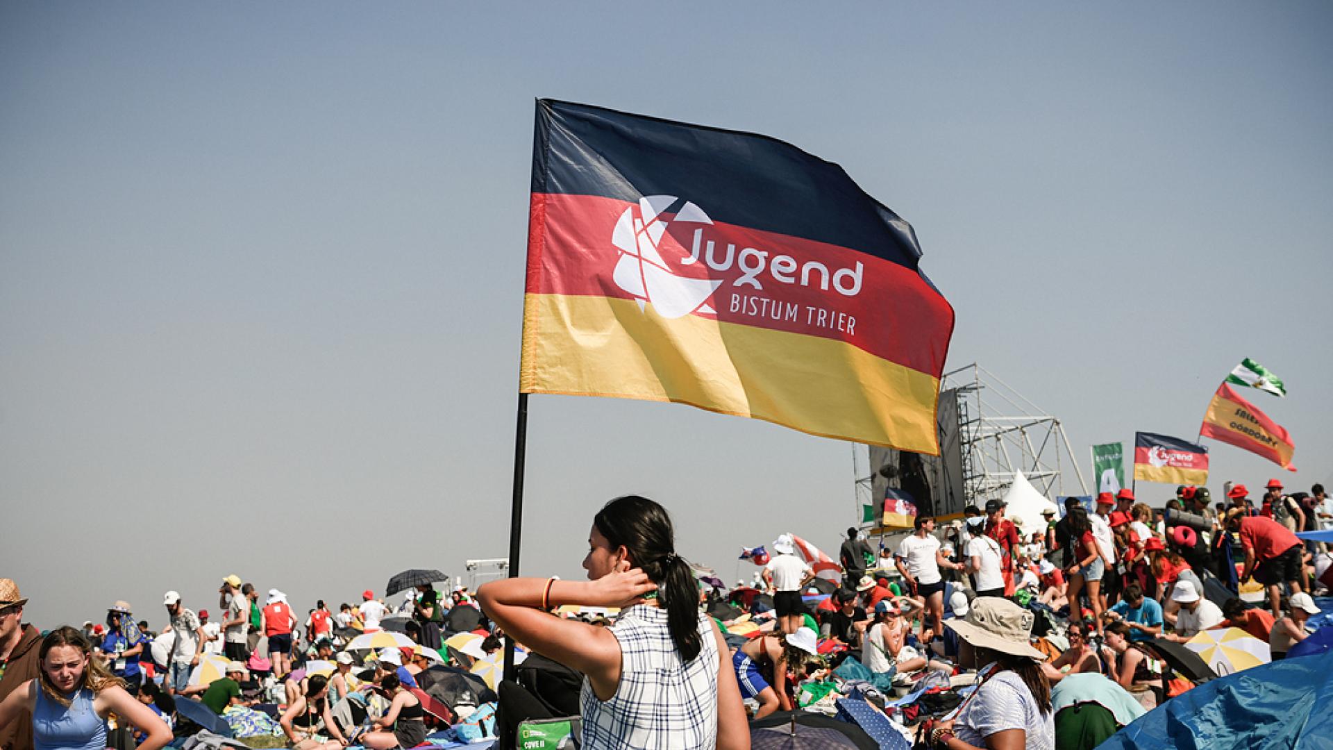 Blick auf die Menge beim Weltjugendtag mit einer Deutschlandflagge und der Aufschrift "Jugend im Bistum Trier"