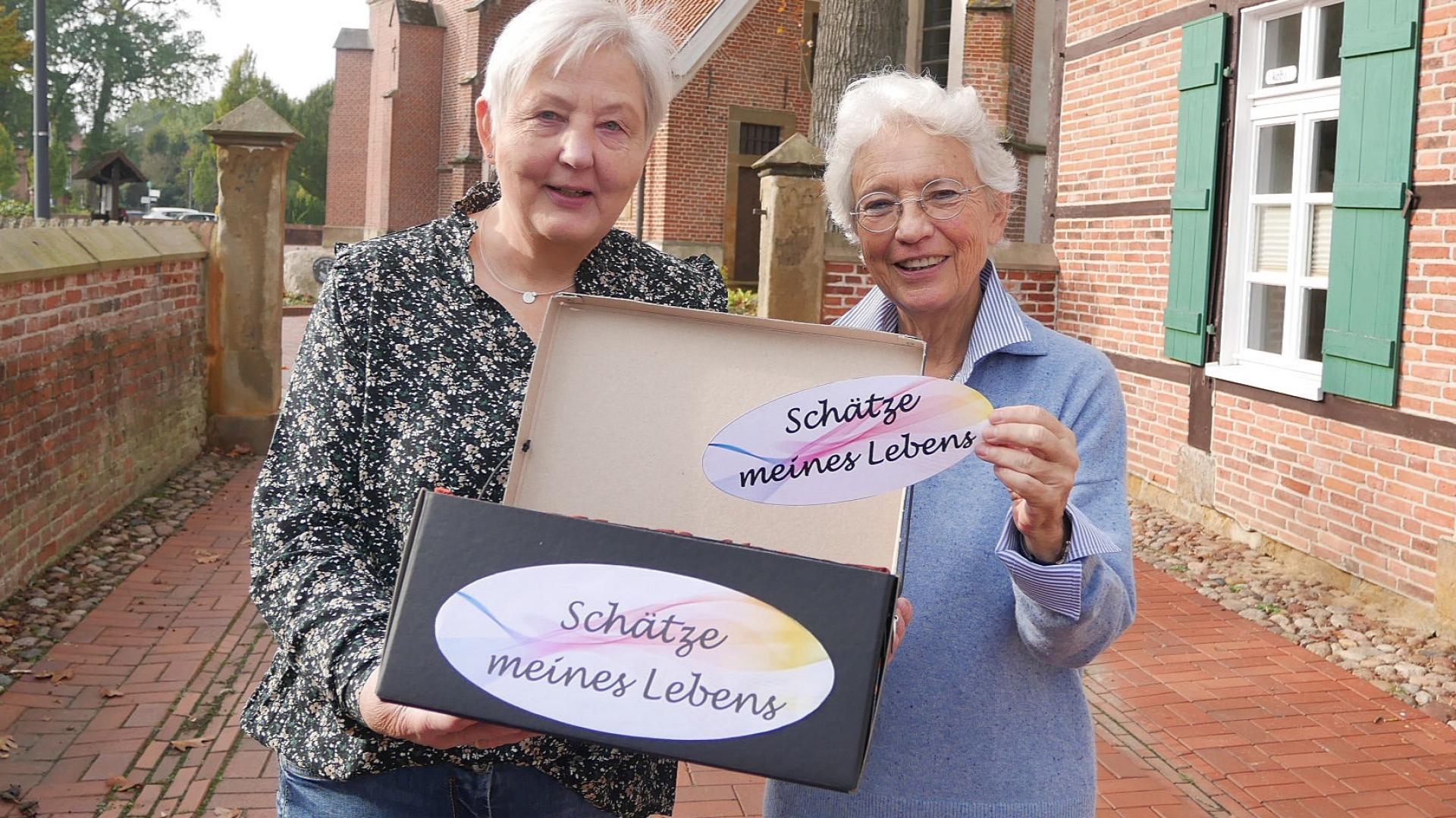 Zwei Frauen zeigen eine Schachtel mit der Aufschrift "Schätze meines Lebens"