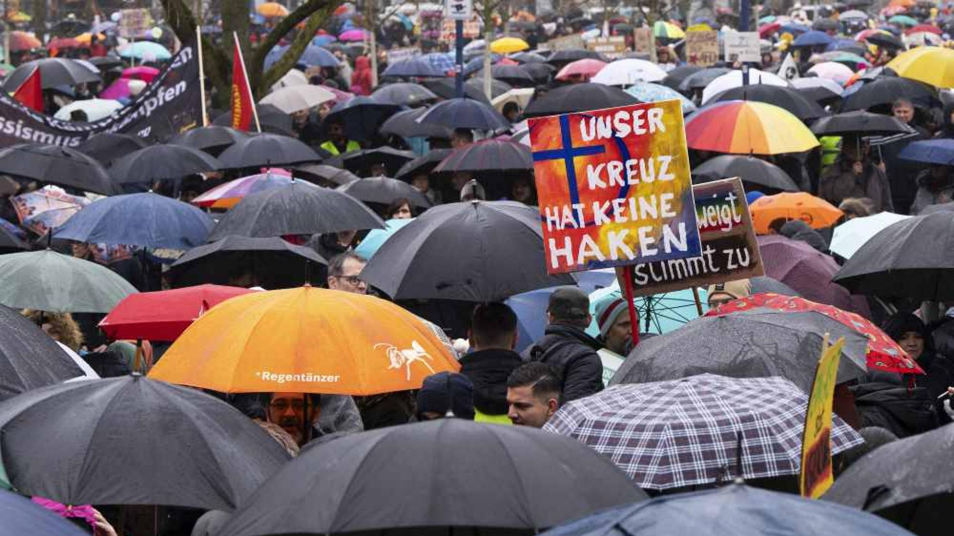 Demonstration gegen die AfD bei Regenwetter in Krefeld. Auf einem Schild steht "Unser Kreuz hat keine Haken".