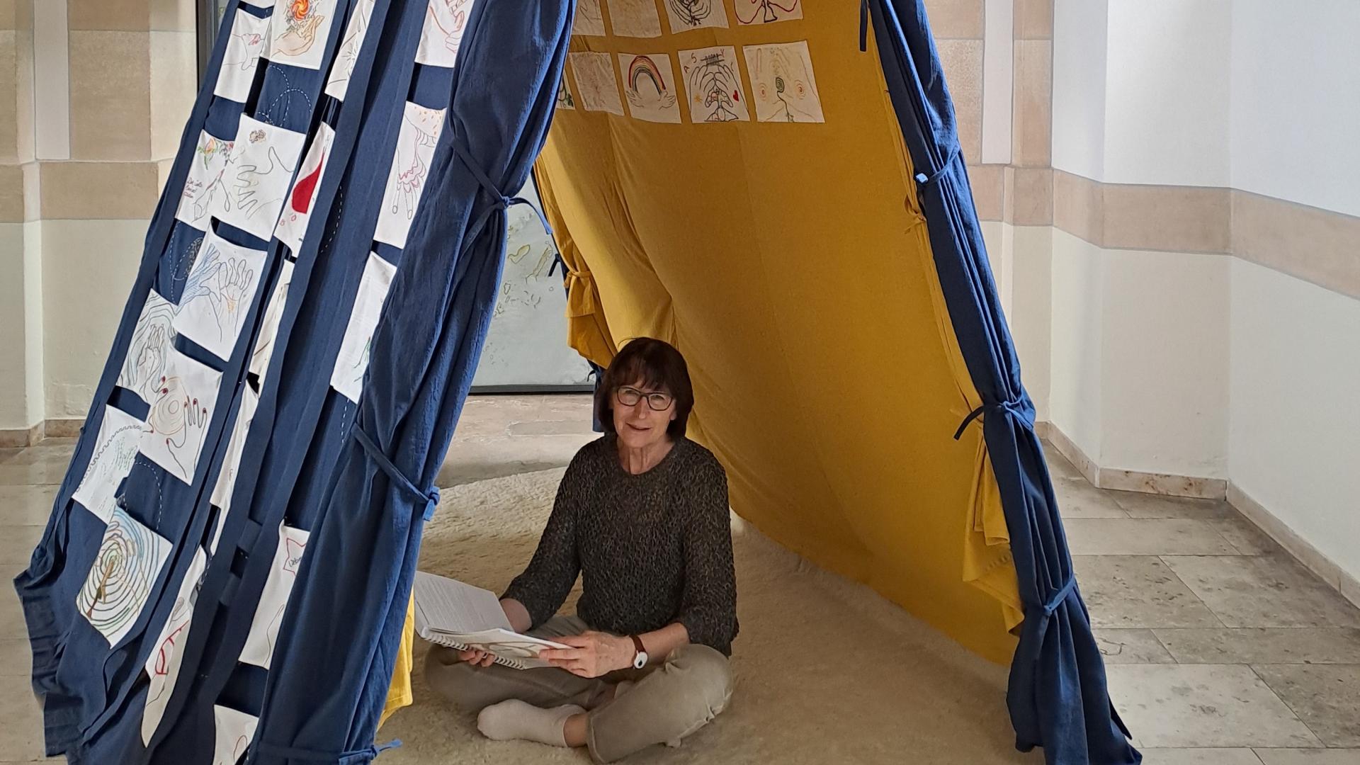 eine Frau sitzt in einem Zelt
