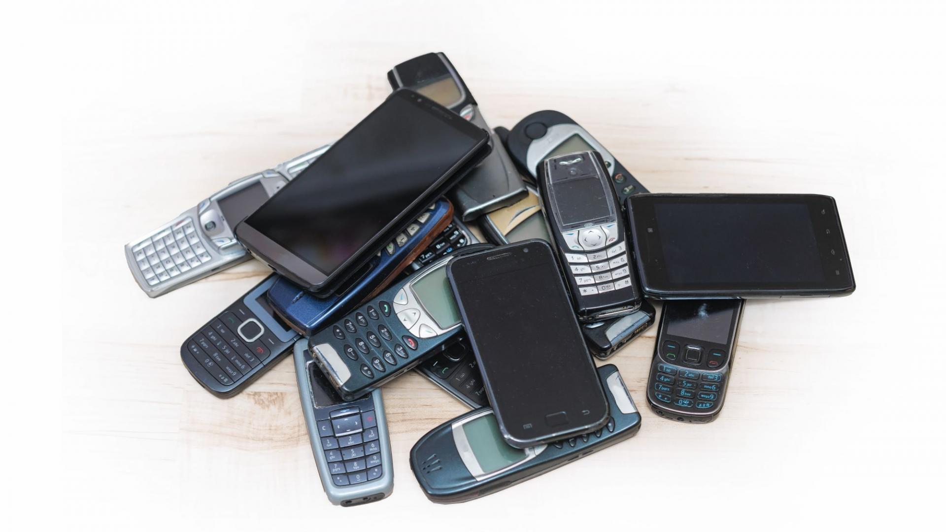 Alte Handys liegen auf einem Tisch