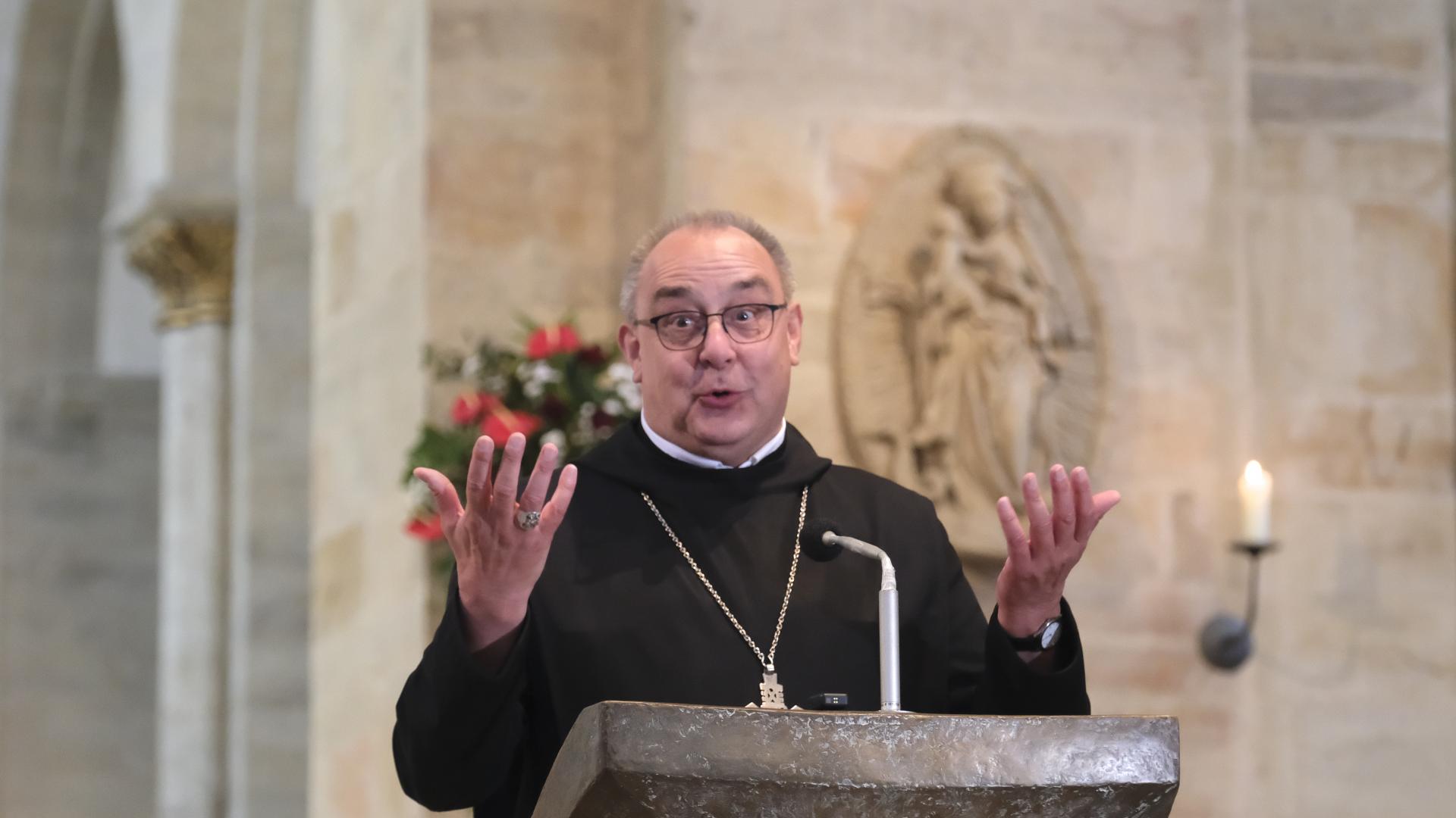 Bischof Dominicus Meier steht am Ambo im Dom und hebt einladend die Hände