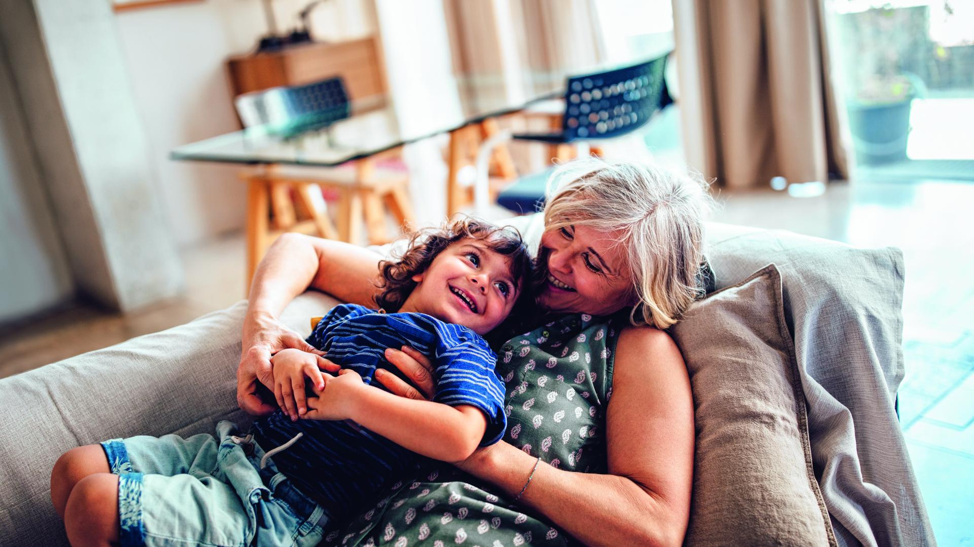 Eine ältere Frau hat einen Jungen im Arm.