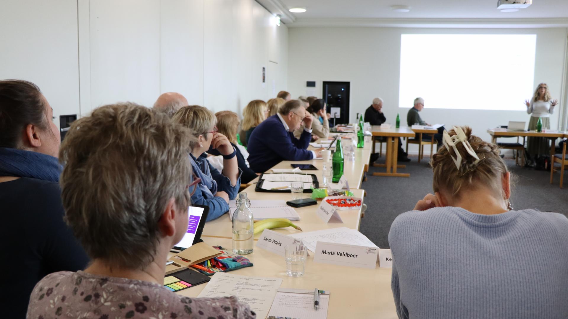 Mehrere Menschen sitzen in einer Runde