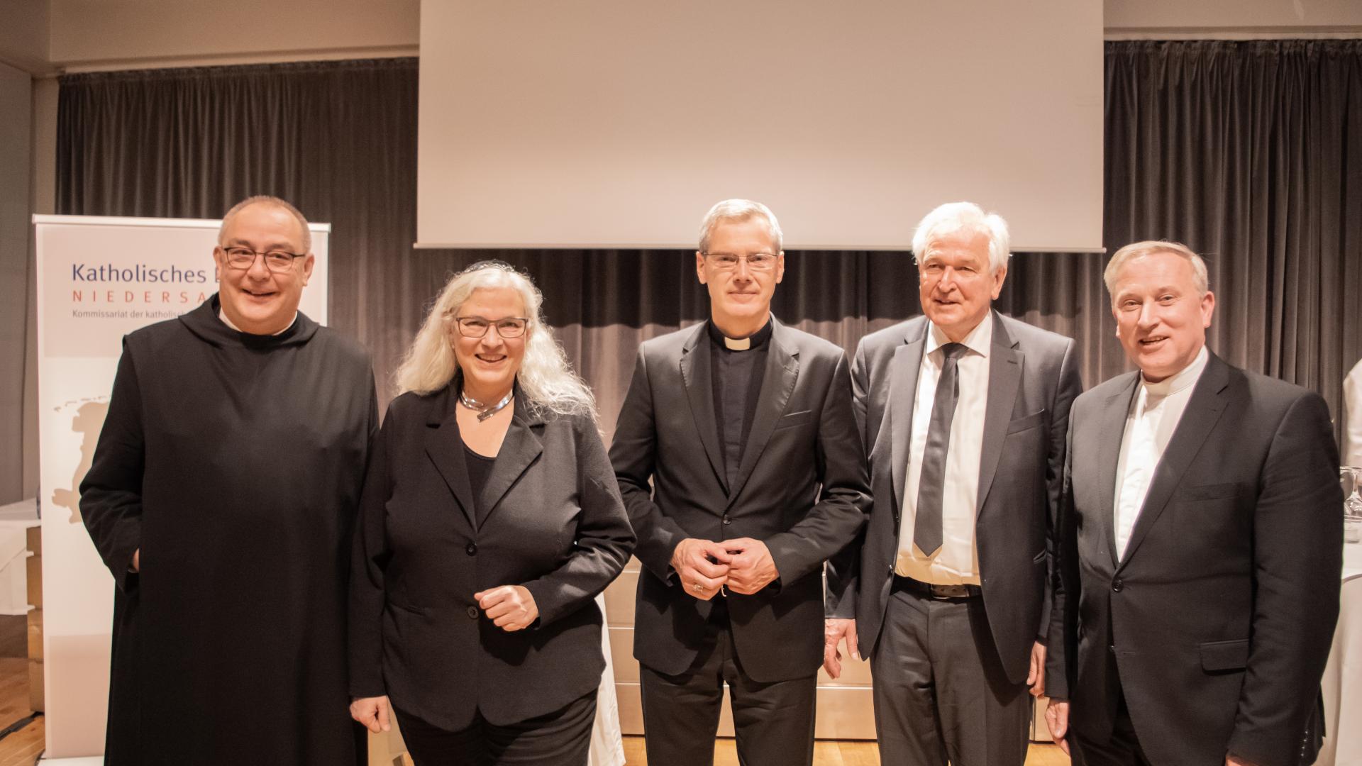 Vier Männer und eine Frau bilden ein Gruppenbild