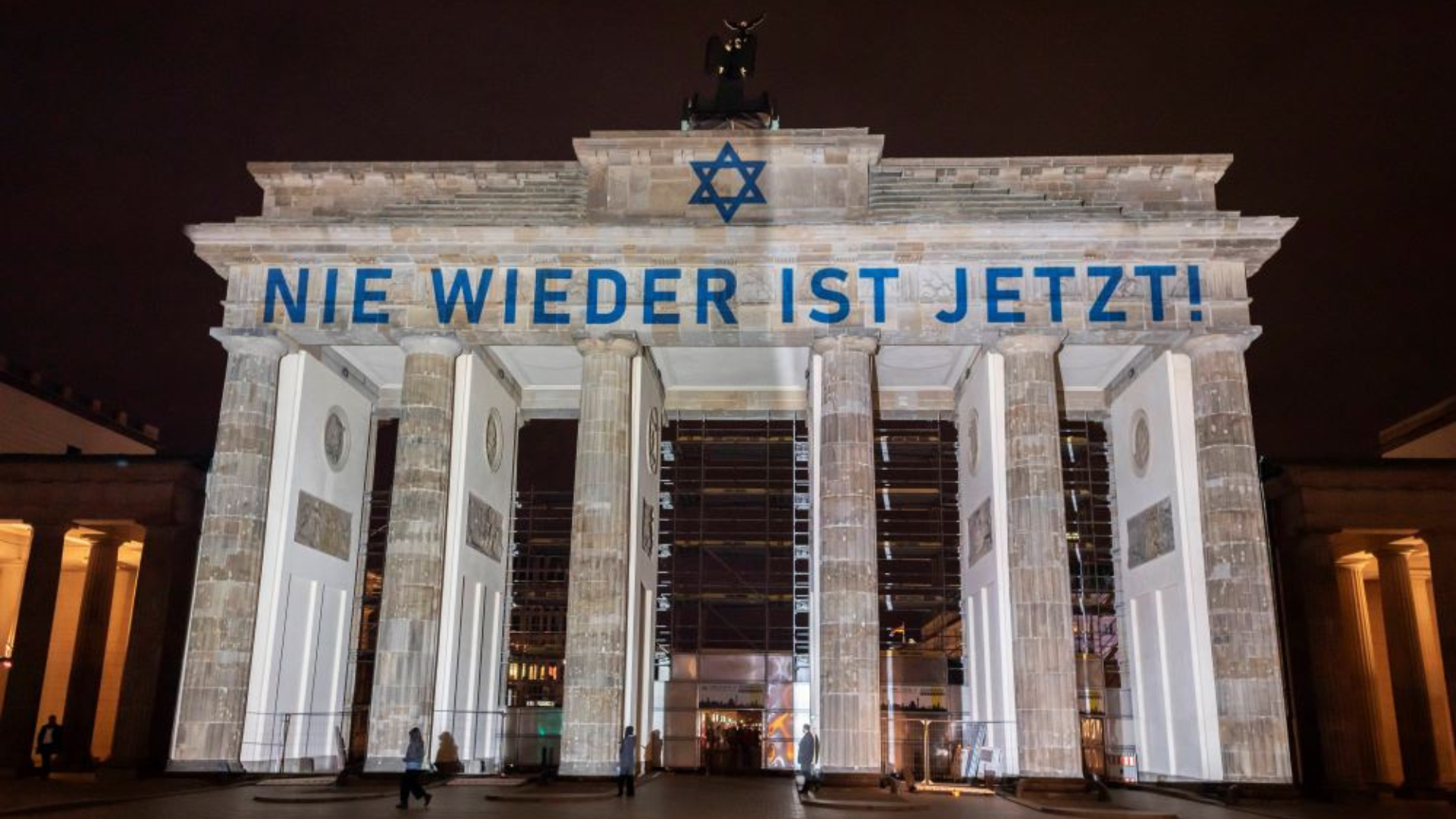 Auf dem Brandenburger Tor sind der Schriftzug „Nie wieder ist jetzt!“ und der Davidstern zu sehen.