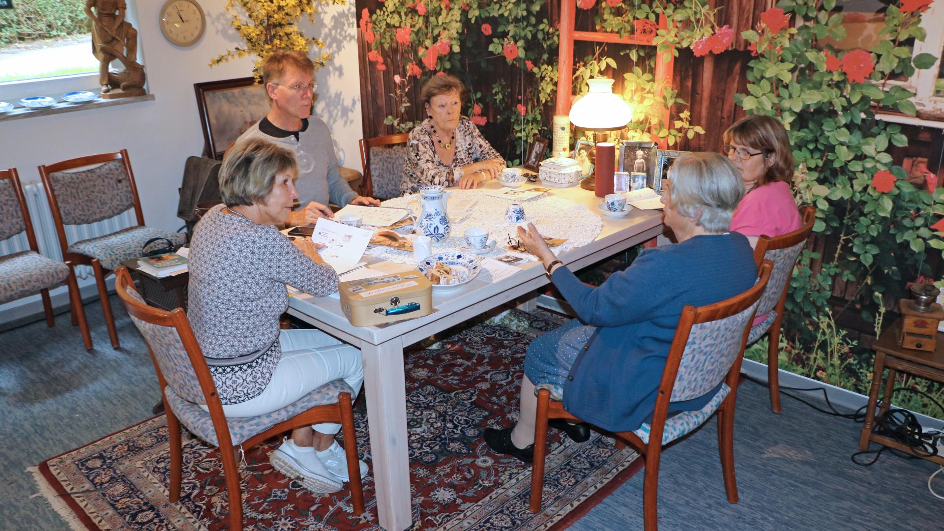 Menschen sitzen gemeinsam um einen Tisch.