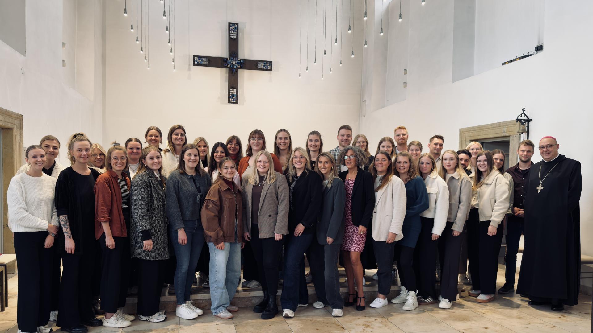Junge Männer und Frauen stehen zusammen mit dem Bischof Dominicus Meier in einer Kirche.