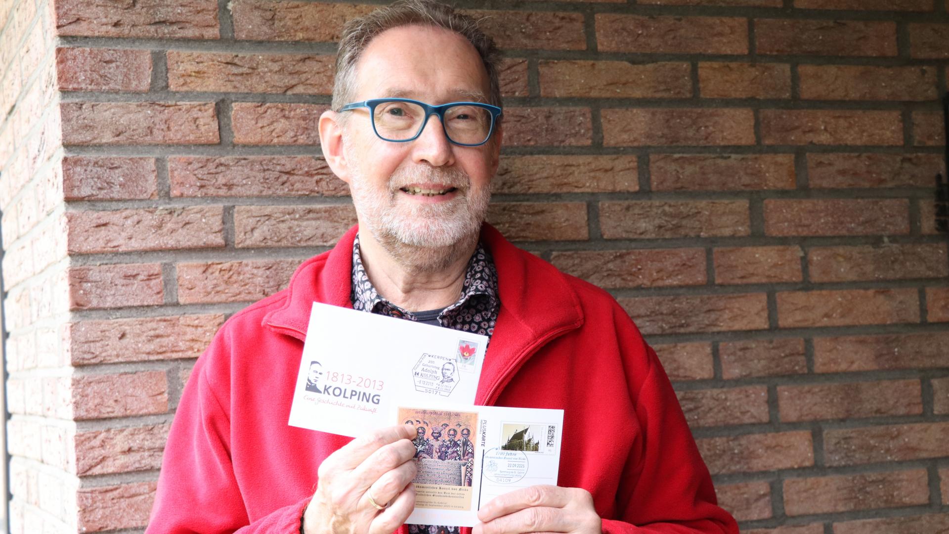 Der Vorsitzende der Sammlergilde St. Gabriel Heinz-Bernd Diekhoff zeigt die Pluskarte, die für das Treffen in Leipzig gedruckt wurde. 