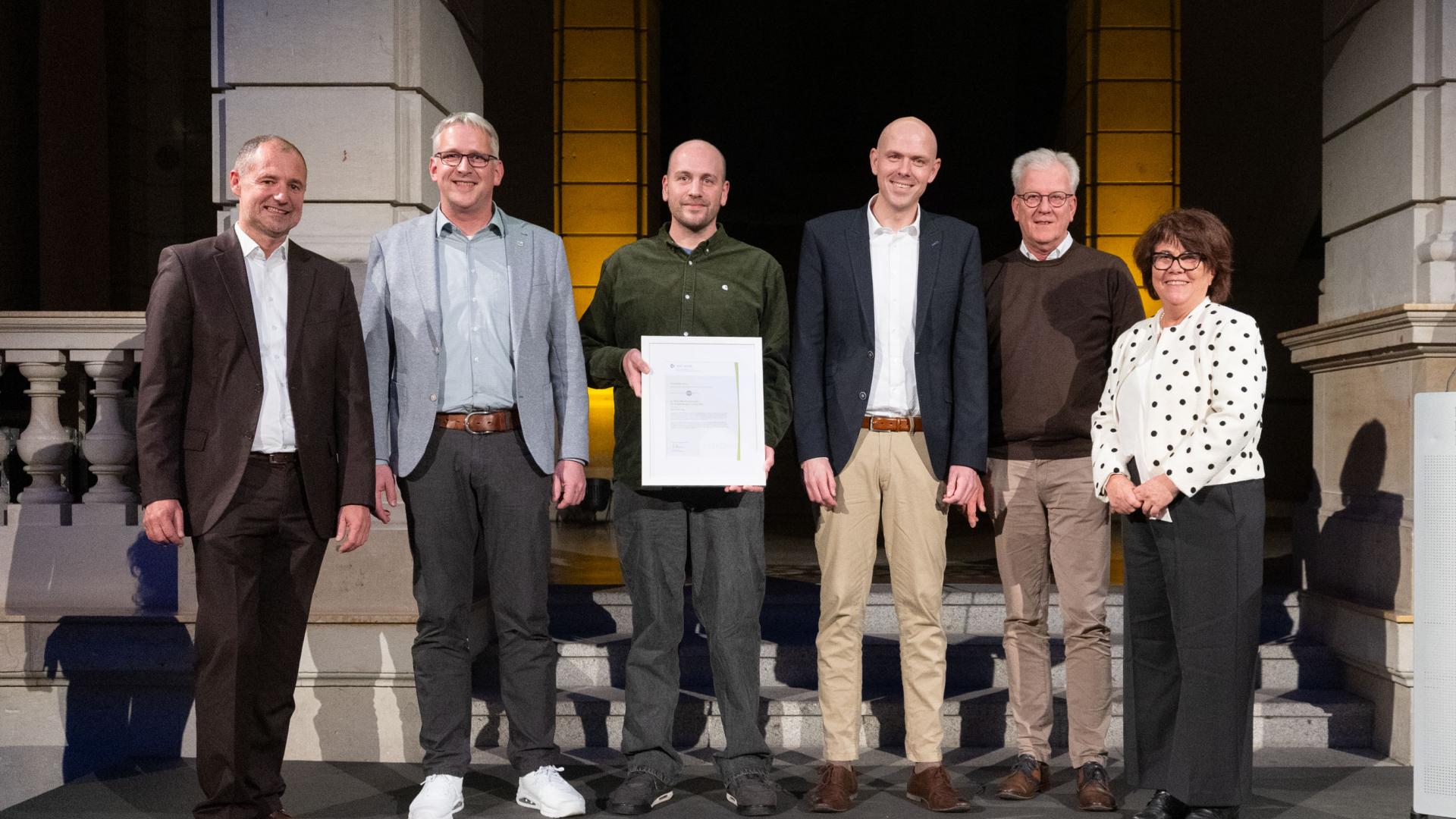 Sechs Menschen mit Urkunde