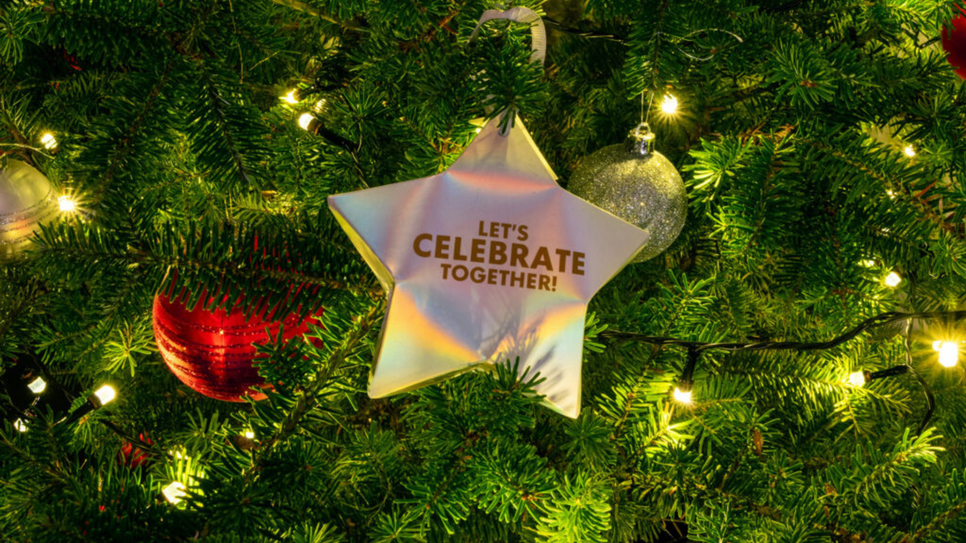 Ein glänzender Stern hängt an einem Weihnachtsbaum