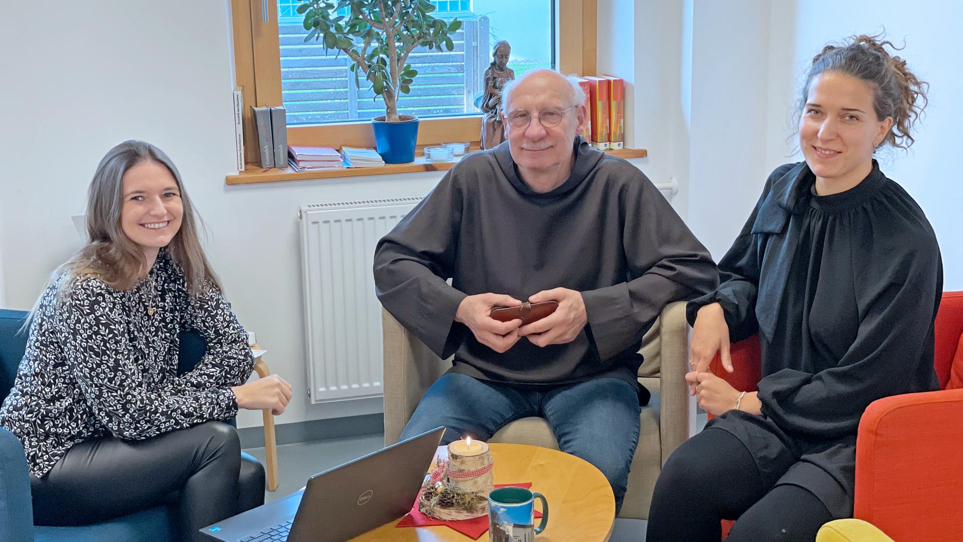 Drei Personen lächeln in die Kamera.