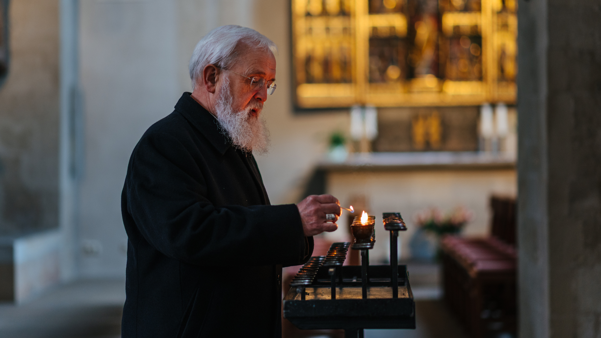 Mann zündet Kerze an