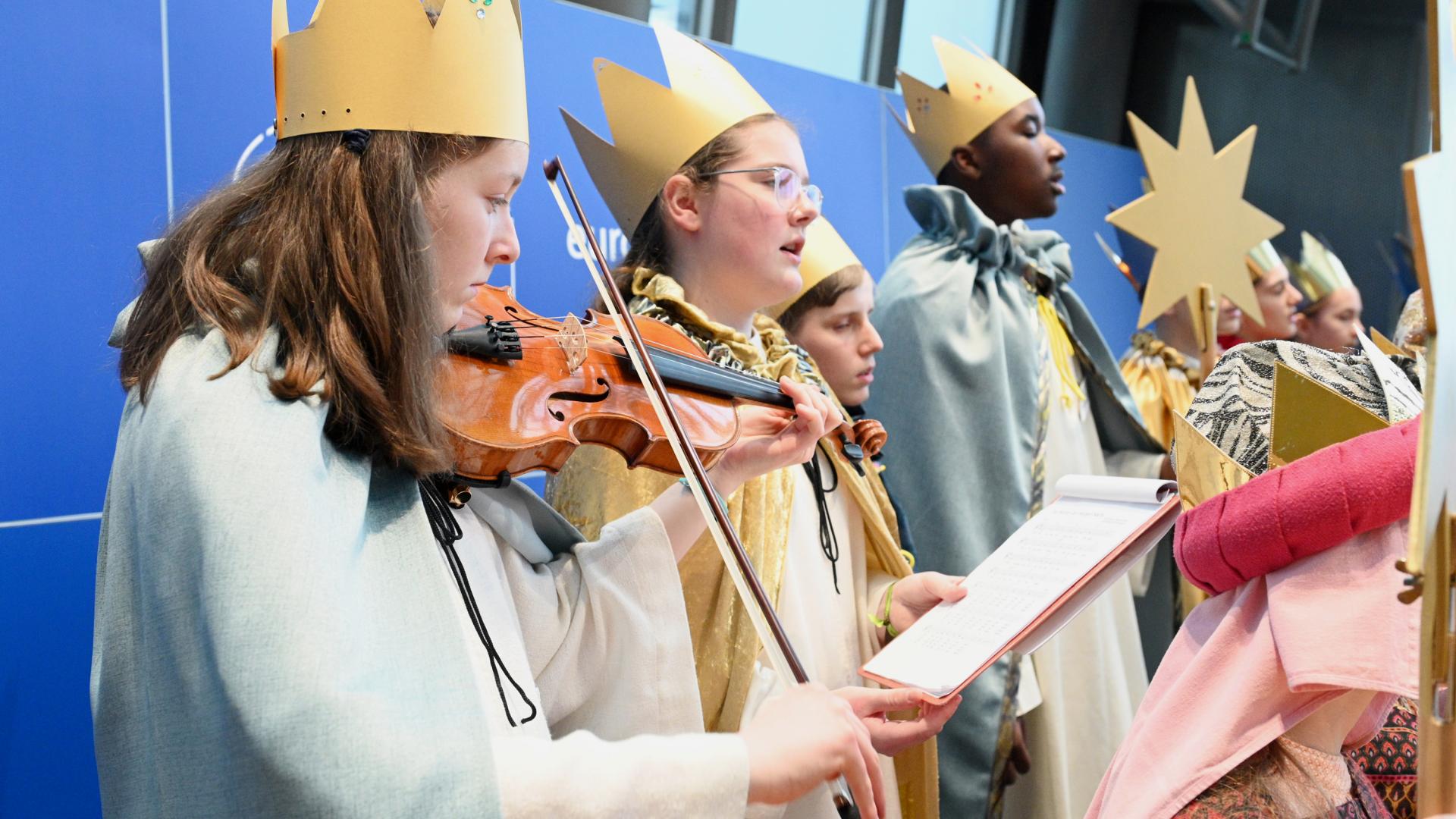 Zu sehen sind singende und musizierende Sternsinger.