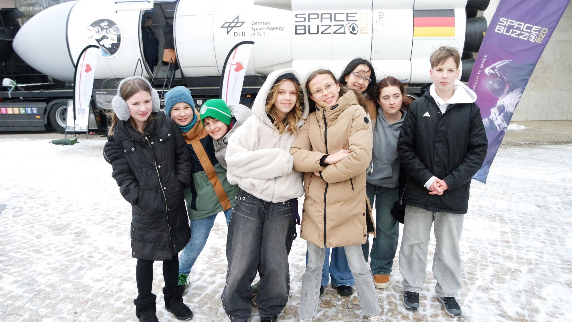 Schüler stehen vor einer Rakete.