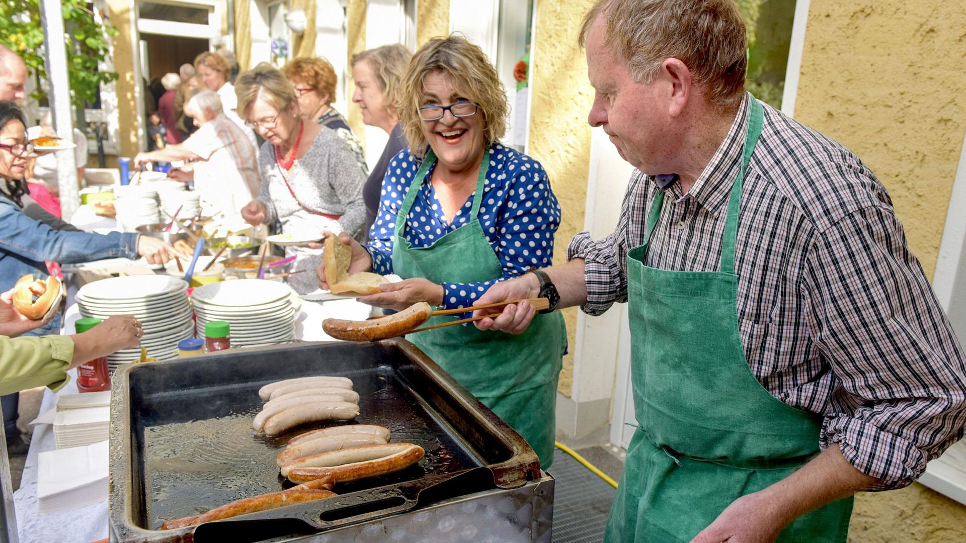 Mann und Frau stehen am Grill