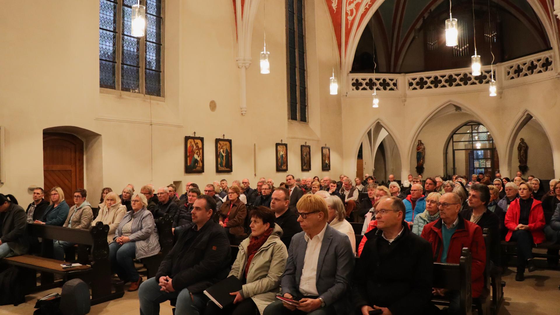 Viele Menschen sitzen in einer Kirche
