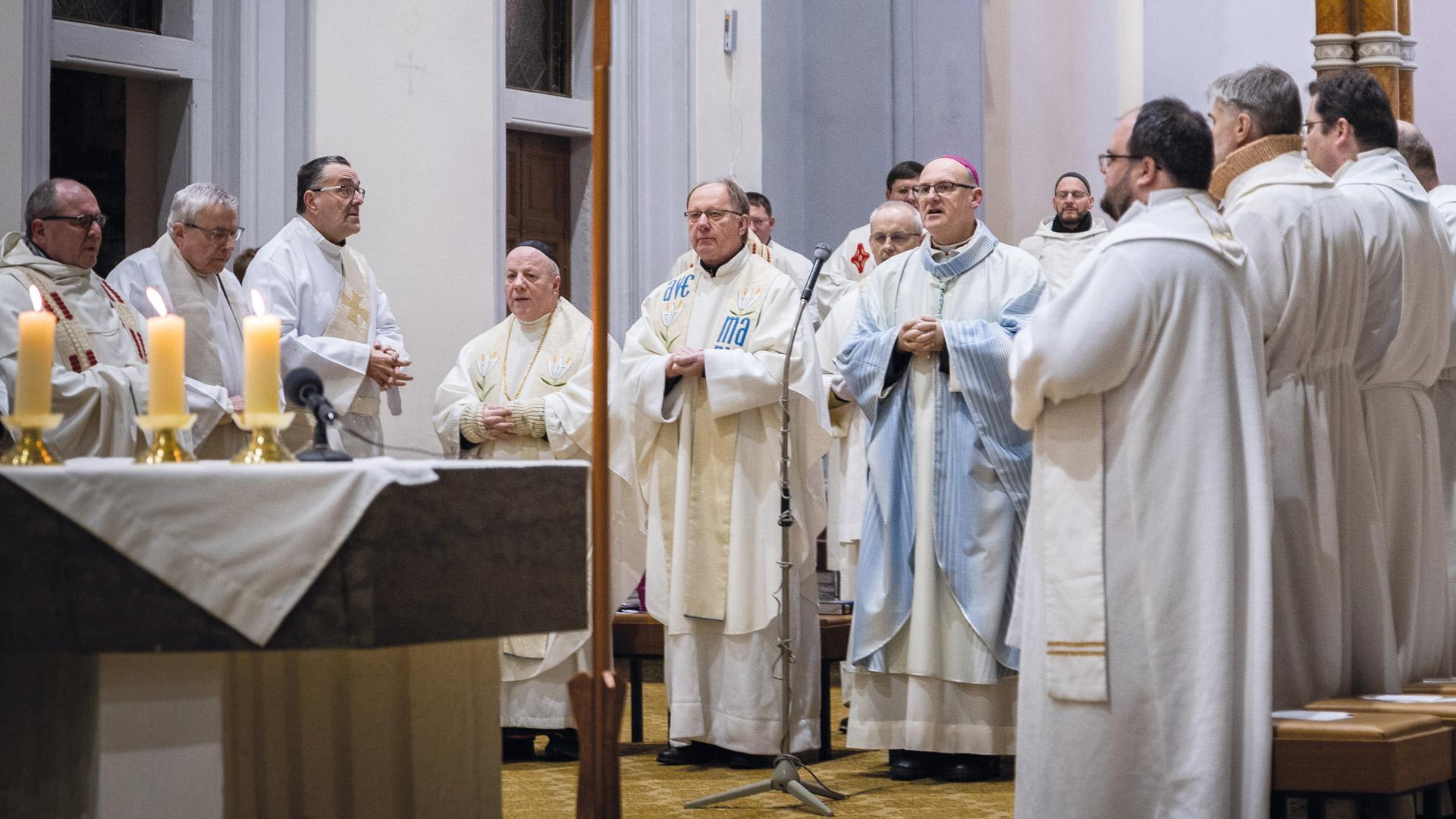 katholische Geistliche stehen während einer Heiligen Messe am Altar