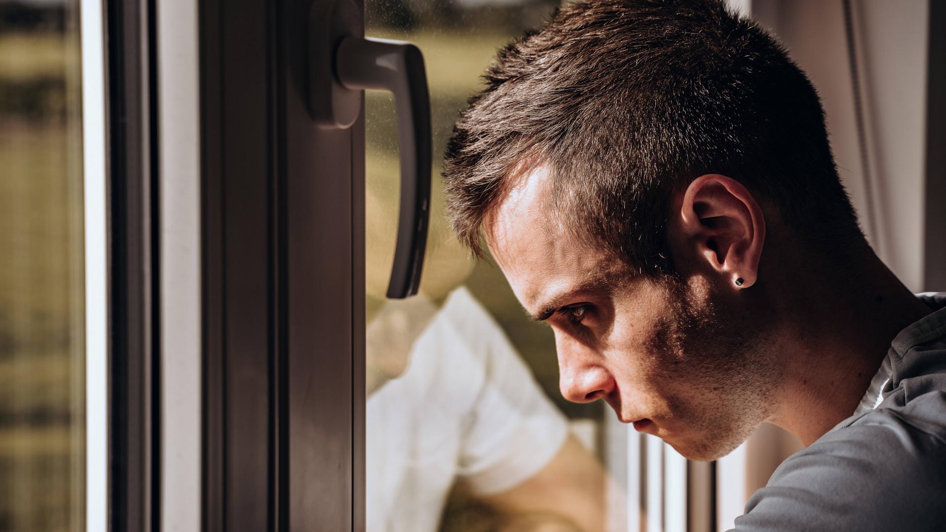 ein junger Mensch an einem Fenster