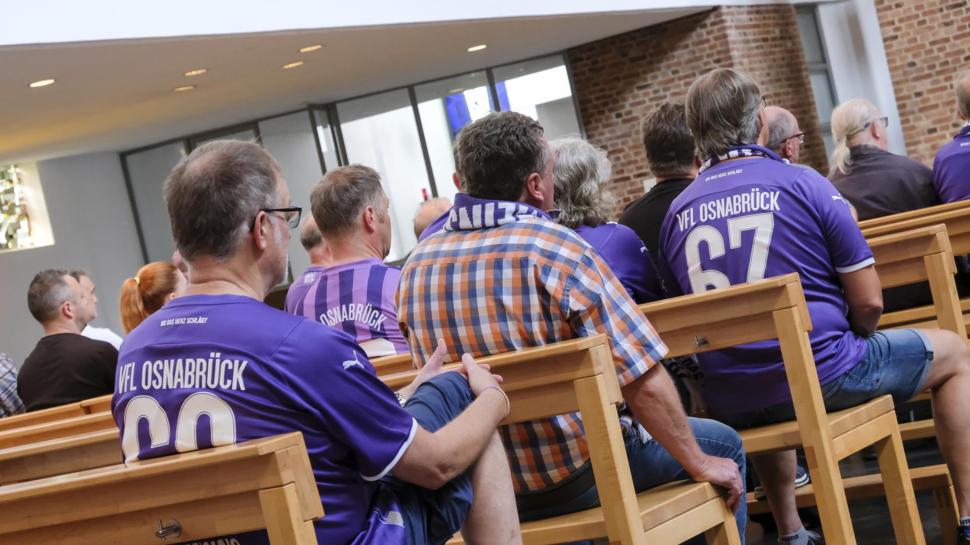 Menschen mit VFL Trikot in Kirche