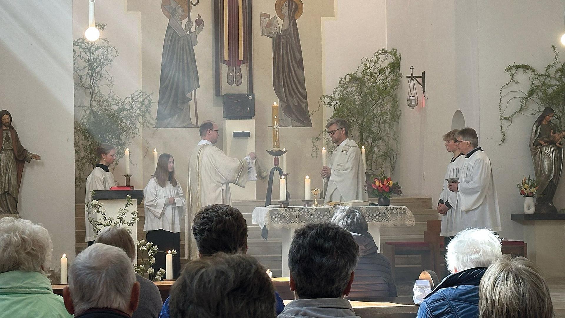 blick in den Altarraum einer katholischen Kirche während einer heiligen Messe – Priester und Ministranten sind zu sehen