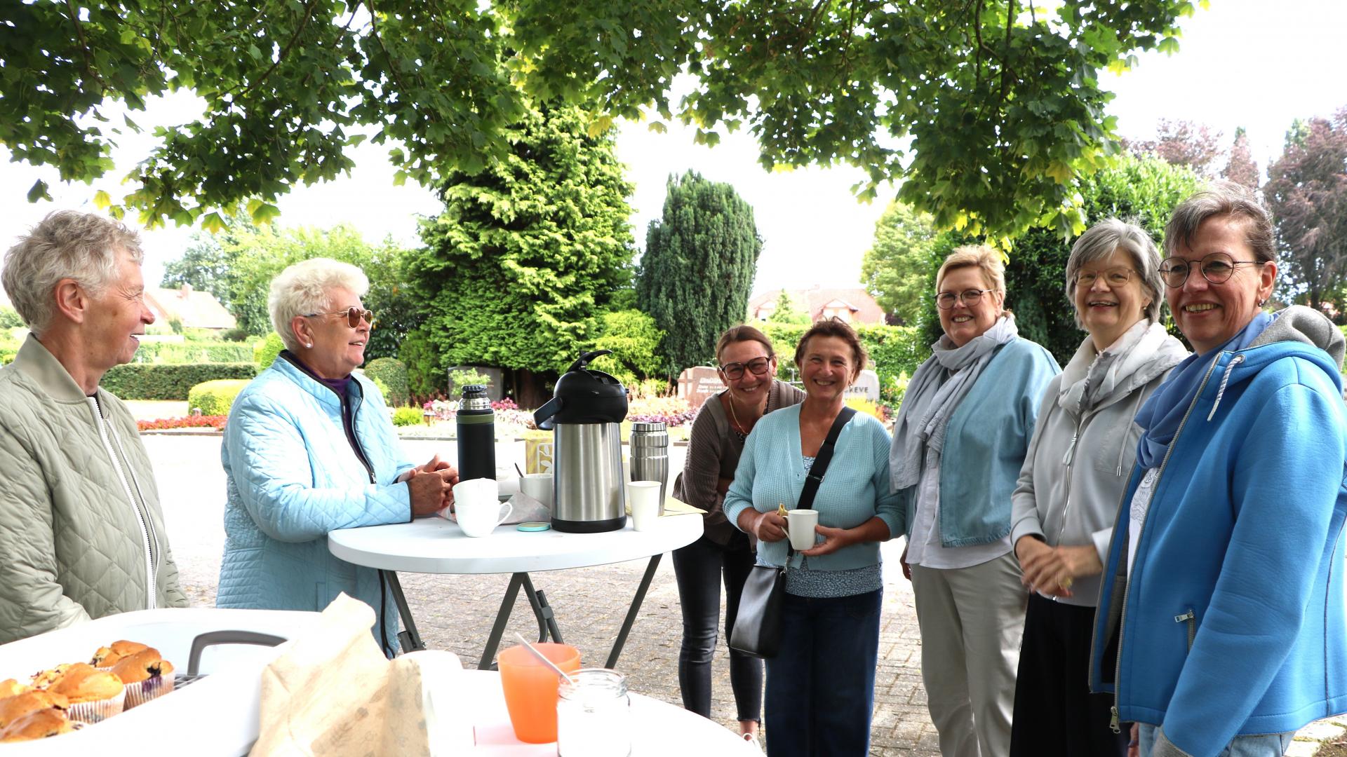 Frauen an Stehtischen unterhalten sich in fröhlicher Runde